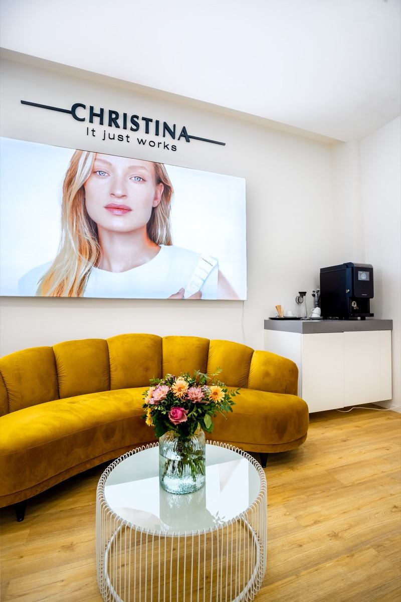 Lounge im Christina House mit Sofa, Kaffeeecke und Christina-Wandlogo